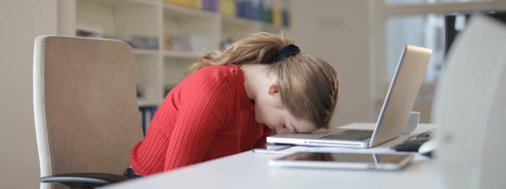 girl burntout laying head on computer keyboard