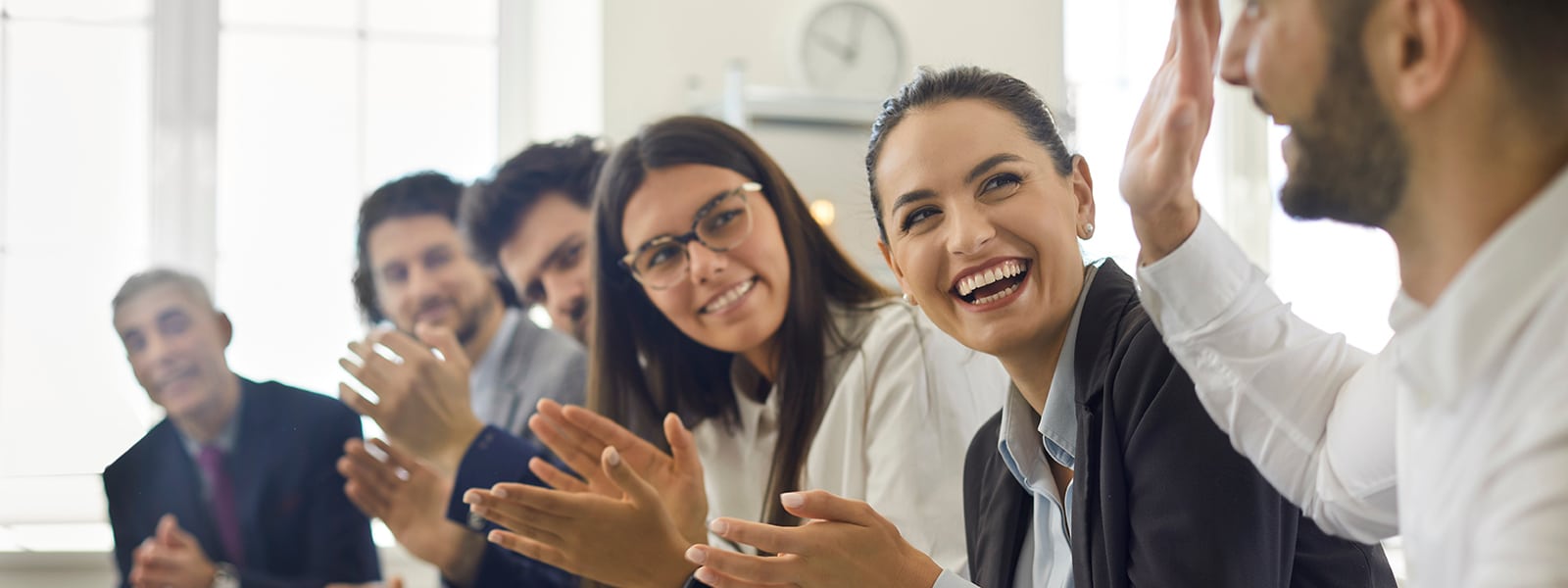 Group of people thanking speaker for interesting presentation in professional business conference or seminar. Team of happy male and female company workers applauding colleague in corporate meeting