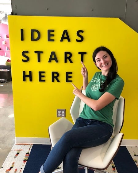 Julia Taylor, GeekPack, sitting in front of a wall with the words: ideas start here