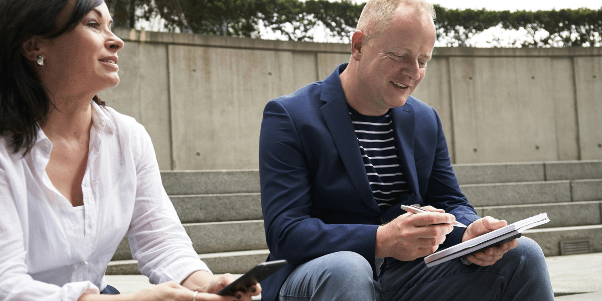 two people sitting and chatting outside