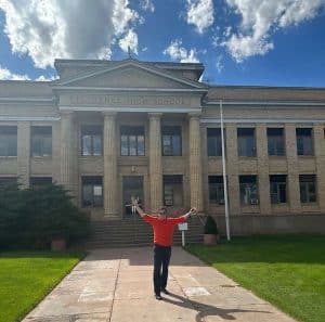 Emergent Campus, man in front of the historic Florence High School