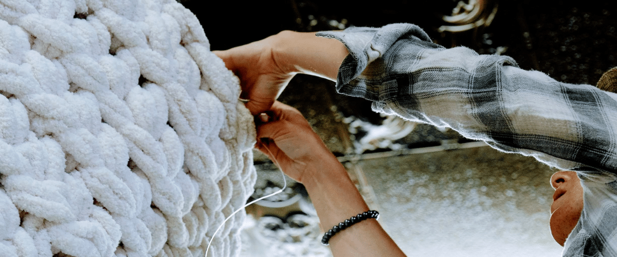 woman working on a textile-based art piece