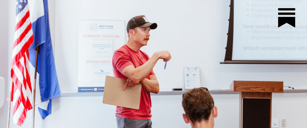 man leading a discussion in front of a classroom