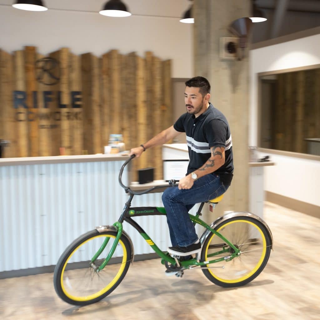 Man on bicycle in Rifle Coworking space, Align Multimedia